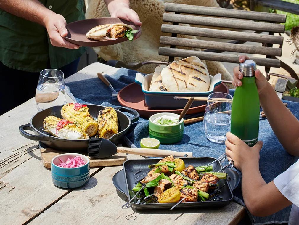 Brochetas de salmón a la parrilla y cebolla tierna con pan de pita tostado